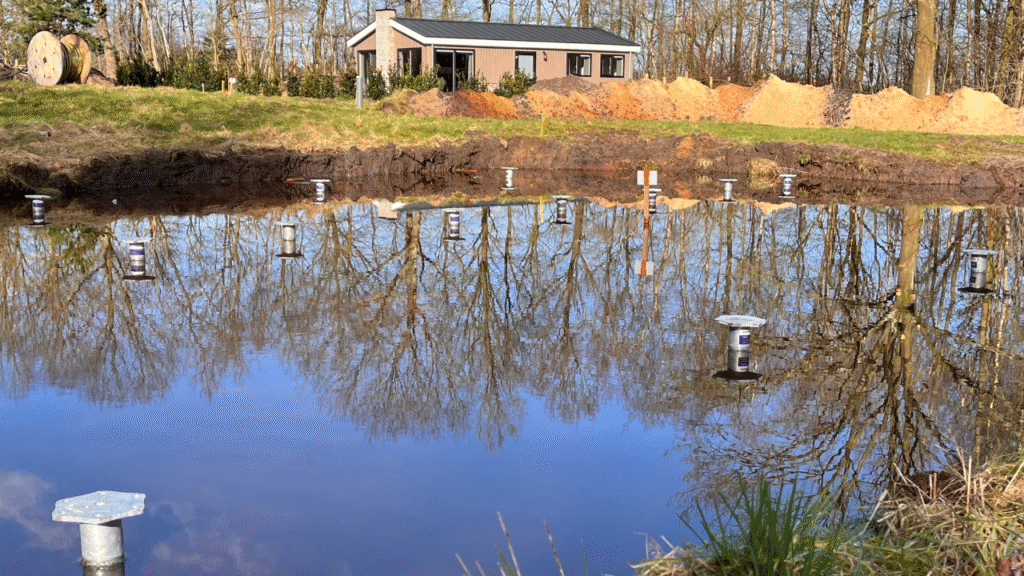 nstallatie van schroeffundering voor houten vlonder in achtertuin